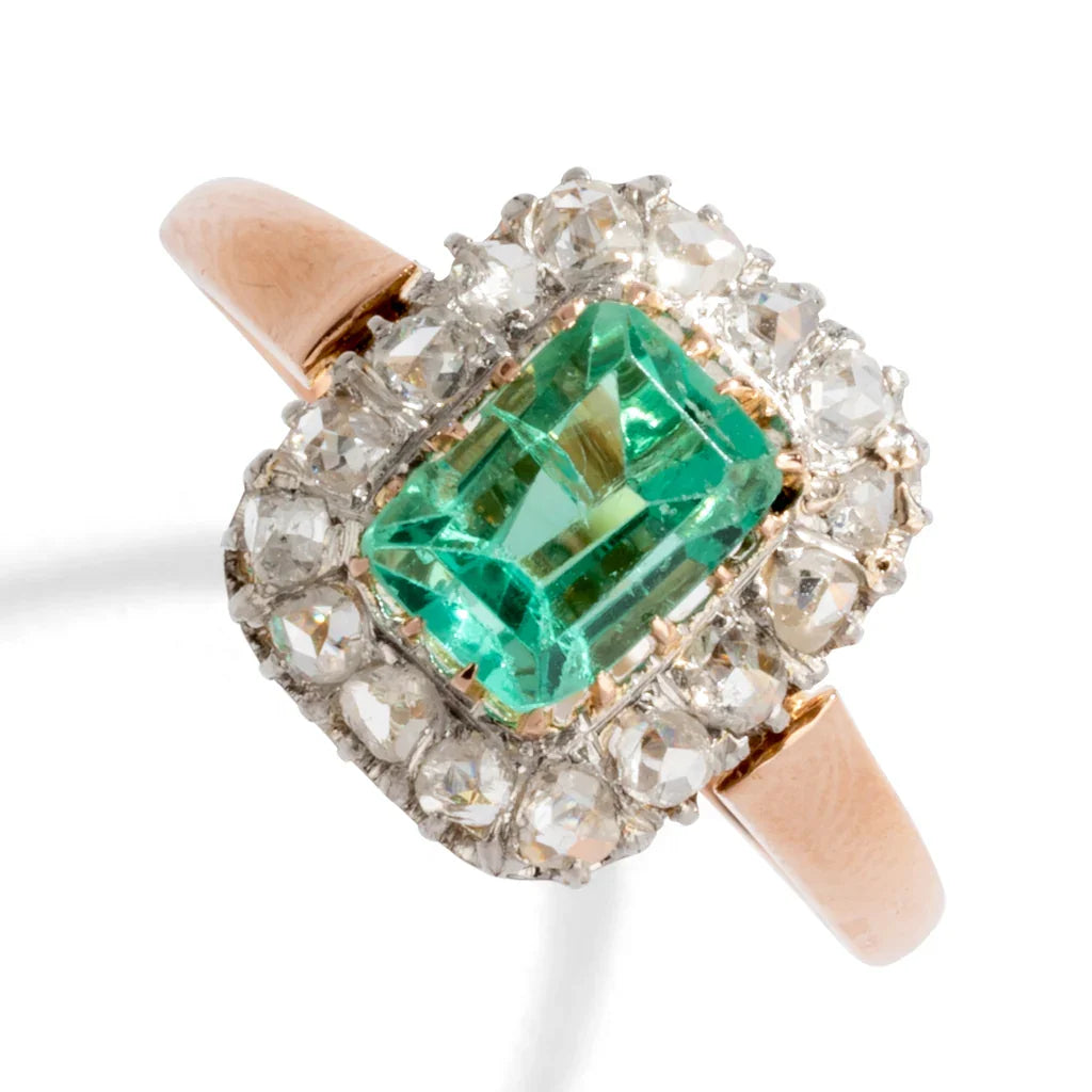 Bague entourage émeraude et diamant.