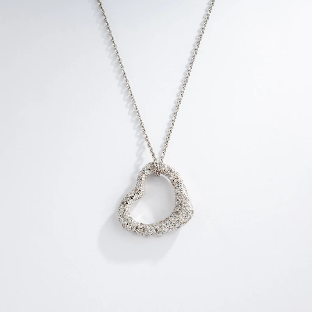 Pendentif en or gris formant un cœur pavée de diamants