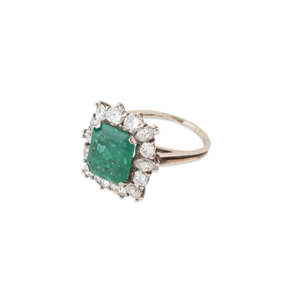 Bague en or gris avec Emeraude entourée de diamants