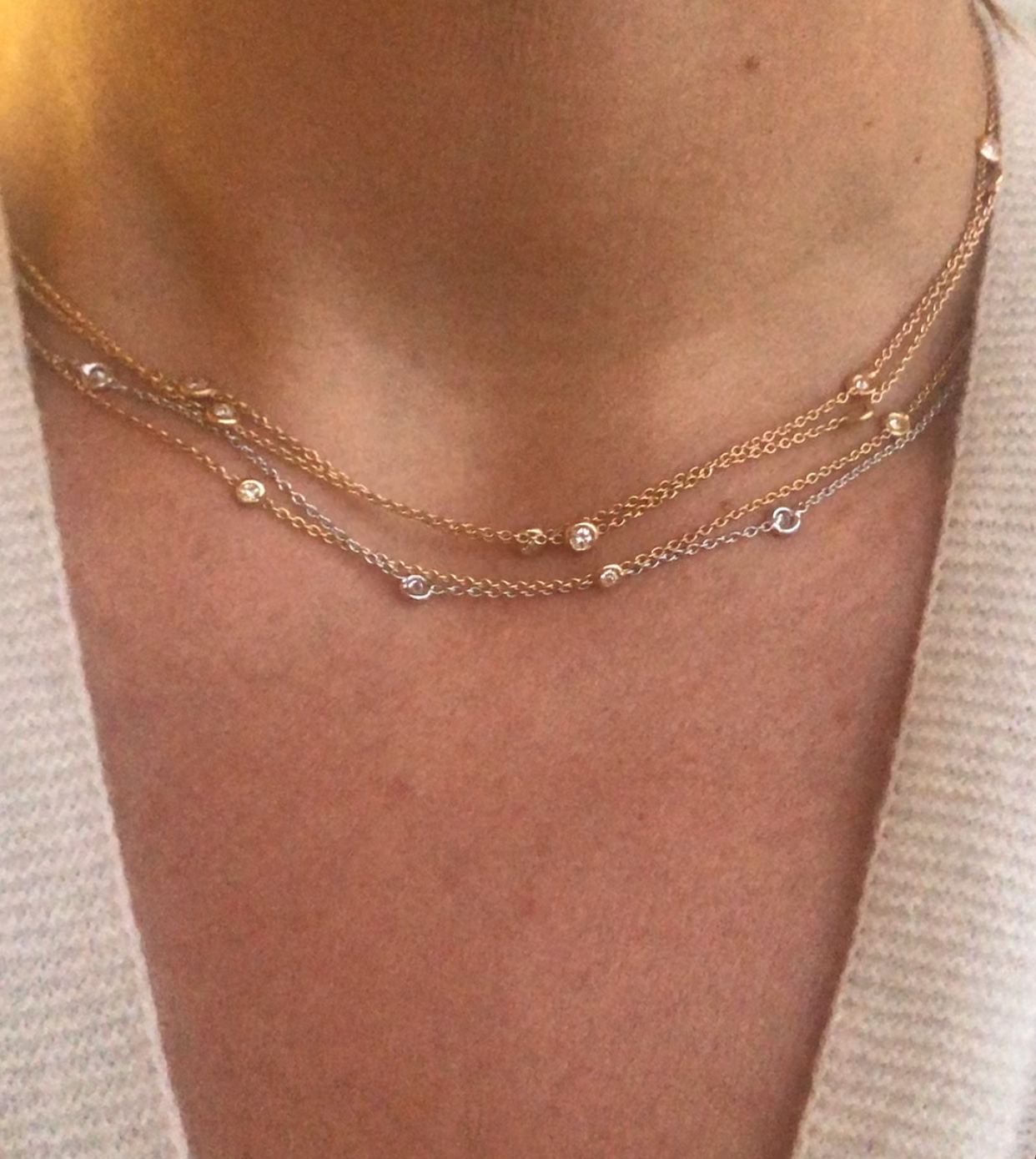 Yellow gold necklace interspersed with 9 diamonds on a cable chain in bezel settings.