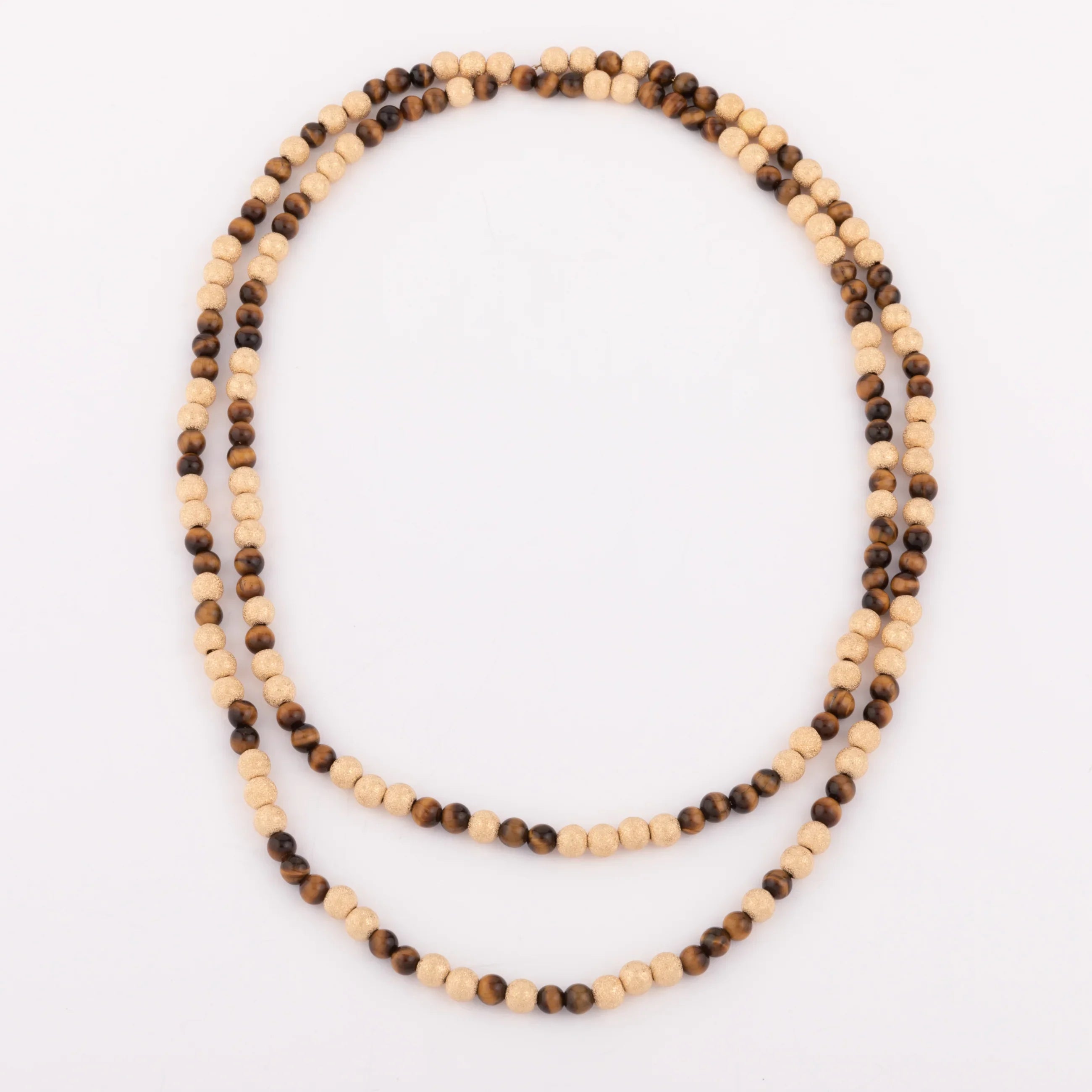 Sautoir en perles d'or ciselés et perle yeux de tigre