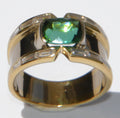 Yellow gold bangle ring adorned with a Tourmaline on a baguette diamond cascade