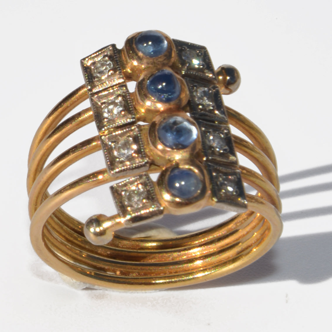 1910 yellow gold ring with cabochon sapphires and diamonds