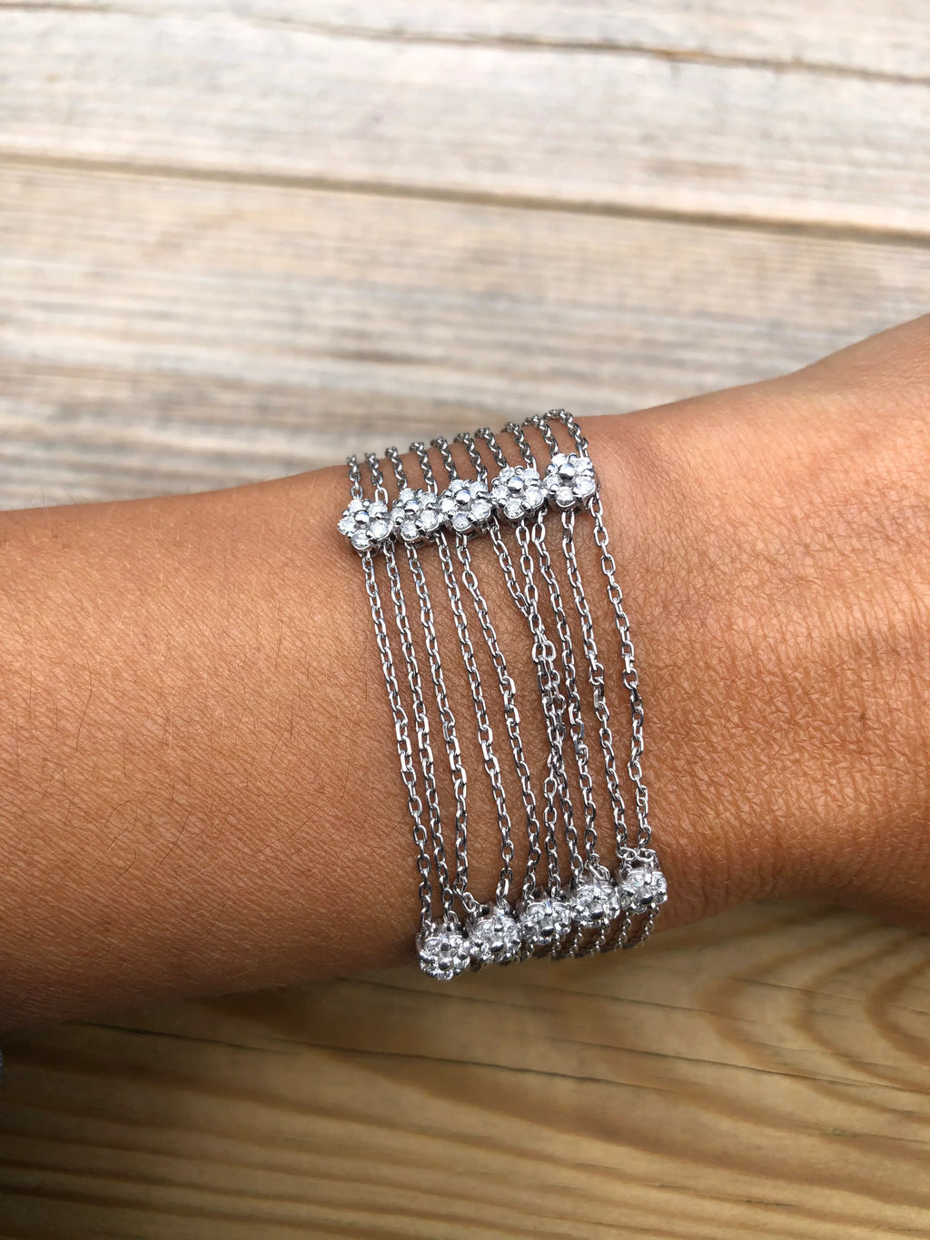 Grey gold and diamond bracelet on a filed cable chain alternating with 4 floral motifs