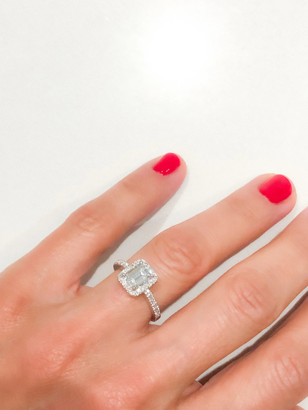 White gold solitaire ring with an emerald-cut diamond