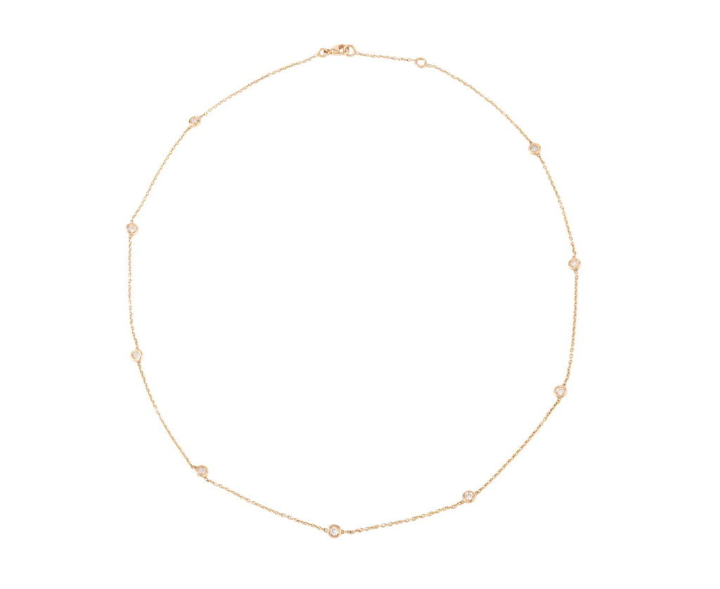 Yellow gold necklace interspersed with 9 diamonds on a cable chain in bezel settings.