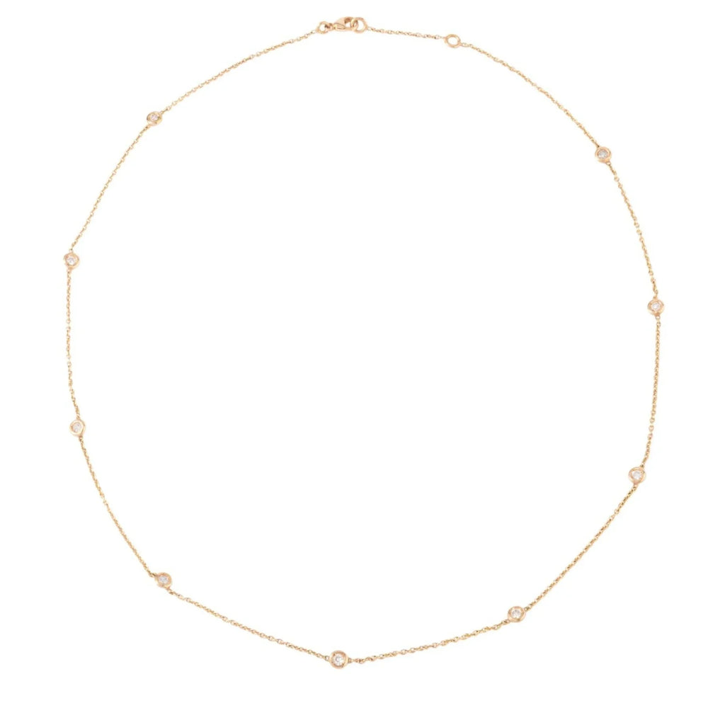 Yellow gold necklace interspersed with 9 diamonds on a cable chain in bezel settings.