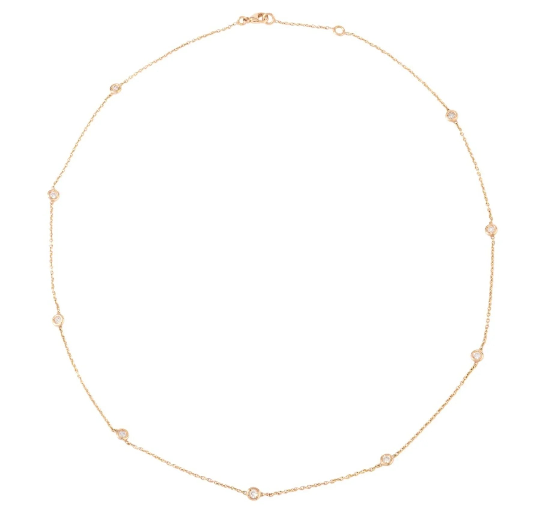 Yellow gold necklace interspersed with 9 diamonds on a cable chain in bezel settings.
