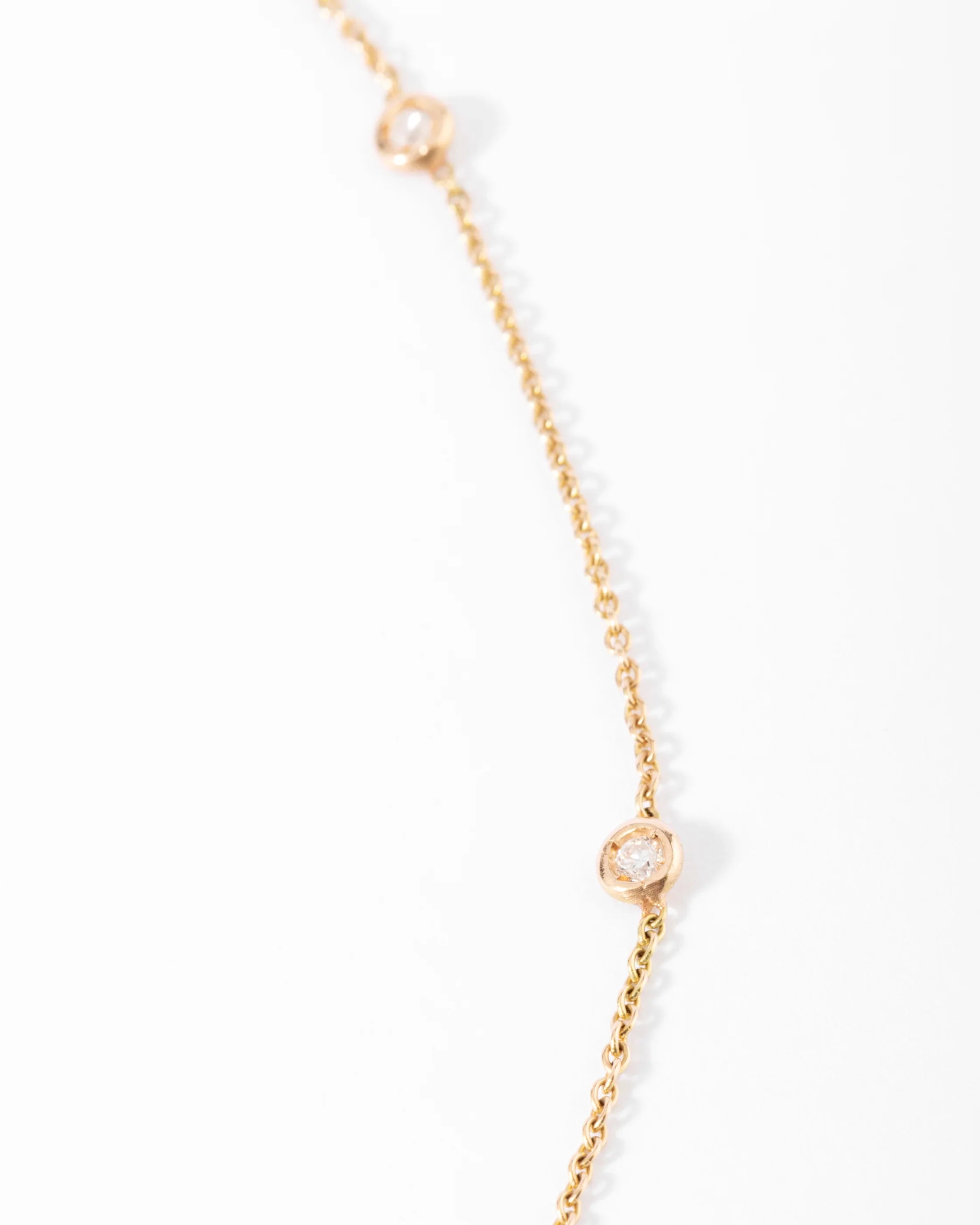 Collier or jaune intercalé de 9 diamants sur maille forçat en sertis clos.